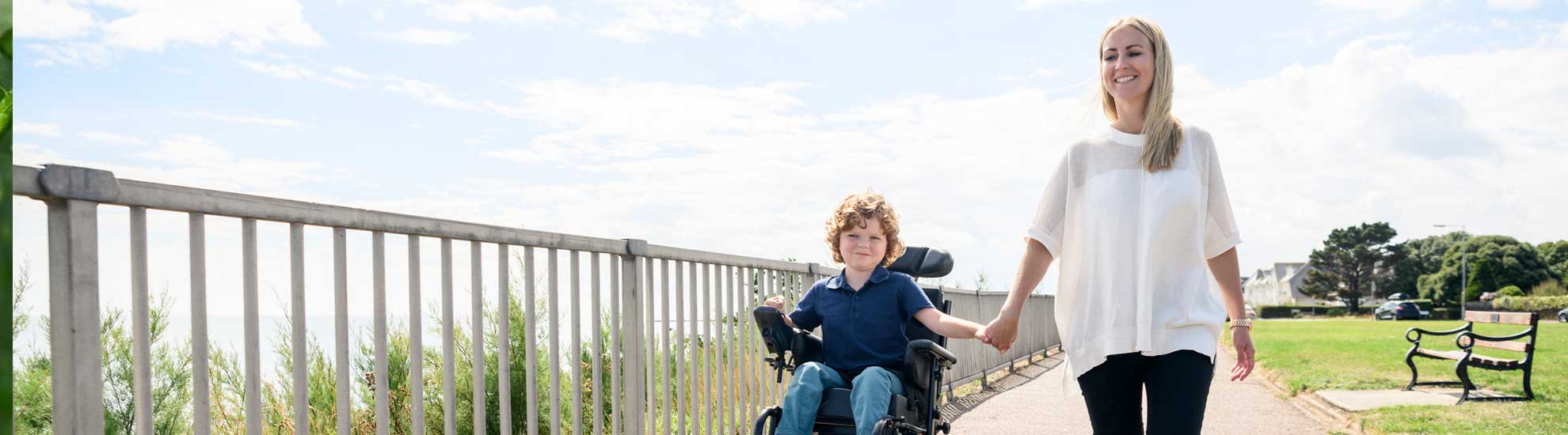 child-in-wheel-chair-with-adult-walking